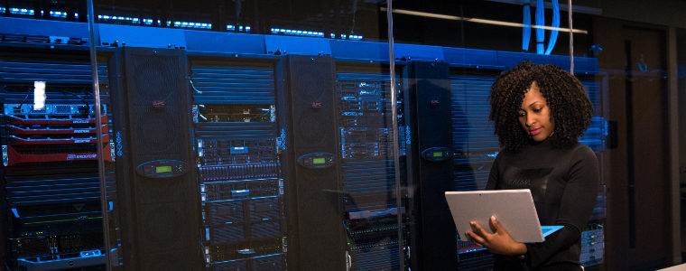 photographie illustrant une femme devant un parc informatique composé de serveurs